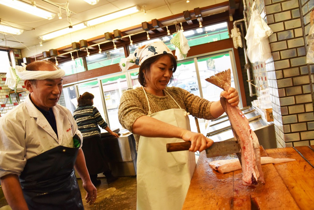 尾を持って身を縦にし、包丁を上から振り下ろすように入れて身と骨を切り離す